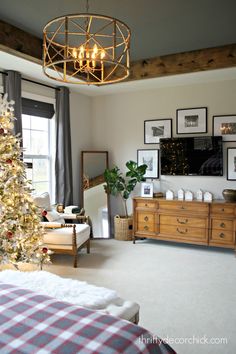 a living room with a christmas tree in the corner and pictures hanging on the wall