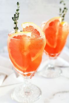 two glasses filled with orange juice and garnish