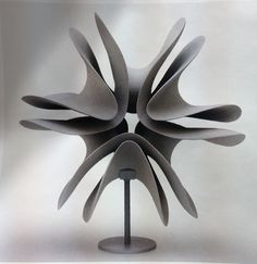 an abstract sculpture is displayed on a white background with black and grey details in the center