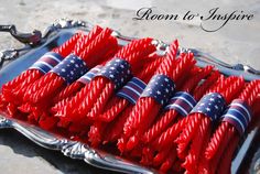 red, white and blue candles are arranged in a tray on the ground with an american flag design