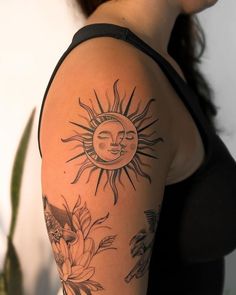 a woman's arm with sun and flowers on it