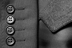 a black and white photo of a suit with buttons