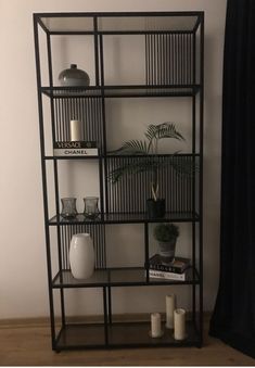 a shelf with some plants and candles on it