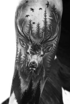 a man's arm with a deer and birds on it, in black and white