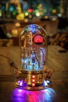 a clock that is sitting on top of a wooden table in front of some lights