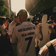 a group of people standing next to each other in front of a building with the number seven on it