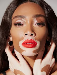 a woman with white paint on her face and hands, posing for the camera while she has