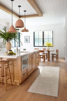 a kitchen with wooden floors and an island in front of the stove top oven next to a dining room table