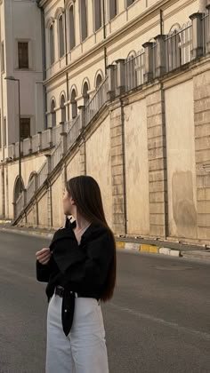 a woman standing in the middle of an empty street