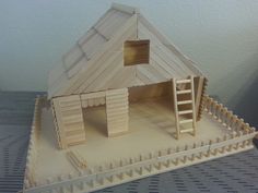 a wooden model of a house with stairs leading up to it