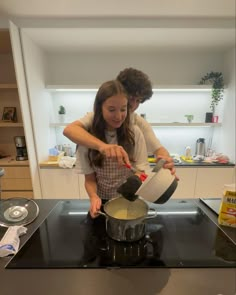 a man and woman are cooking on the stove