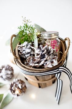 some pine cones are sitting in a basket on a table with other items around it