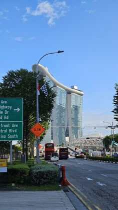 a street sign on the side of a road next to a traffic light and tall buildings