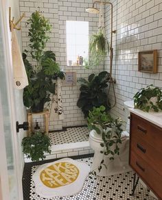 the bathroom is decorated in black and white tiles, with plants on the toilet seat