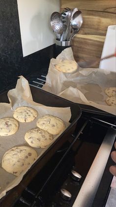 two pans filled with cookies sitting on top of an oven