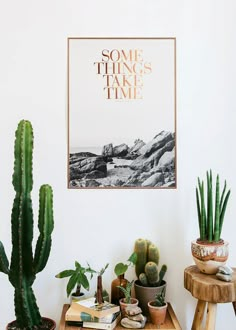 some plants and books are sitting on a table in front of a poster that says some things take time