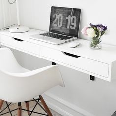 a laptop computer sitting on top of a white desk