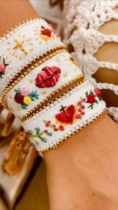 a close up of a person's hand wearing a bracelet with flowers on it