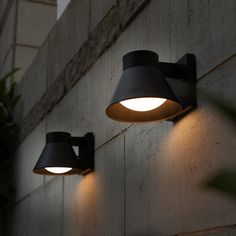 two outdoor lights on the side of a building