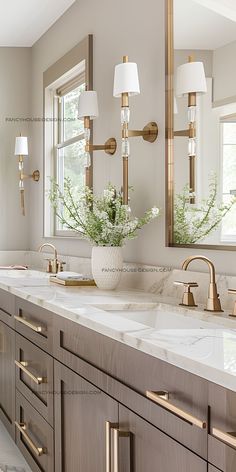 a bathroom with two sinks, mirrors and gold faucets on the countertop