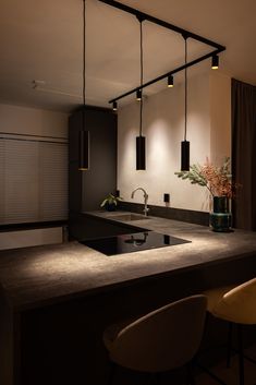 a modern kitchen with an island counter and hanging lights