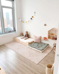 a child's room with wooden flooring and white walls, including a window