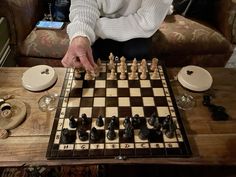 a person playing chess on a coffee table