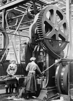 two men working on machinery in an industrial factory