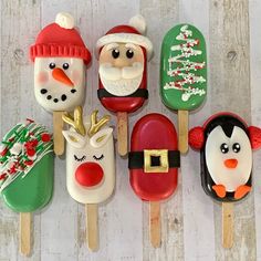 christmas pops decorated with santa claus, snowman, penguin and reindeer on wooden skewers