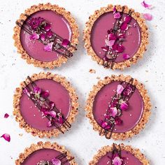 four small pies with pink toppings on top of each one are arranged in rows