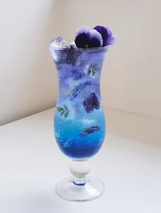 a blue vase with purple flowers in it