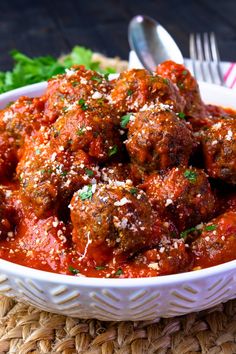 a white bowl filled with meatballs covered in marinara sauce