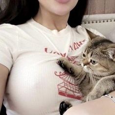 a pregnant woman holding a cat in her arms