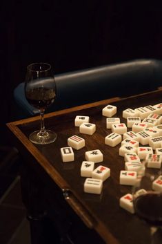 a wooden table topped with dice and a glass of wine