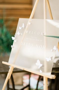 a welcome sign sitting on top of a wooden easel