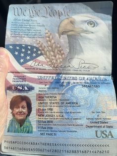 a person holding up a passport with an eagle on it's front and side