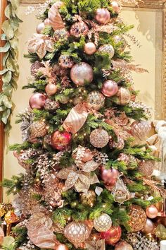 a christmas tree decorated with pink and gold ornaments