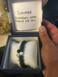 a hand holding a box with a bracelet in it that says, sempre llevas una parte de mi