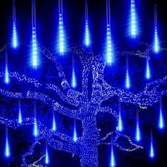 a blue lighted tree in the dark with many lights on it's branches and leaves