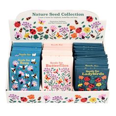 an assortment of seed packets in a box with flowers and ladybugs on them