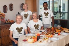 a group of people standing around a table with food on it