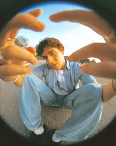 a man sitting on the ground with his hands in front of him