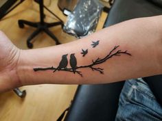 two birds sitting on a tree branch tattoo