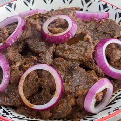 a bowl filled with meat and onions on top of a table