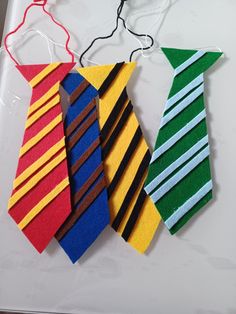 three different colored ties are hanging on a table