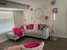 a living room filled with furniture and clocks on the wall