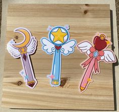 three wooden magnets with different designs on them