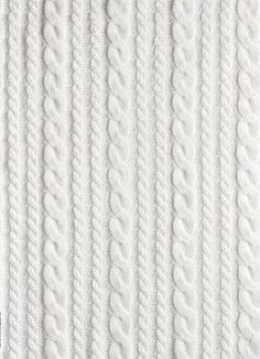 white knitted fabric textured with lines and braids, close - up photo