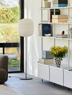 a living room filled with furniture and a book shelf next to a sliding glass door