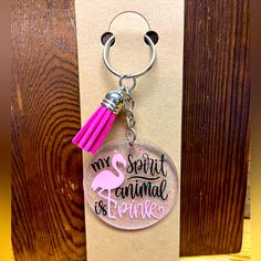 a keychain with a pink tassel hanging from it